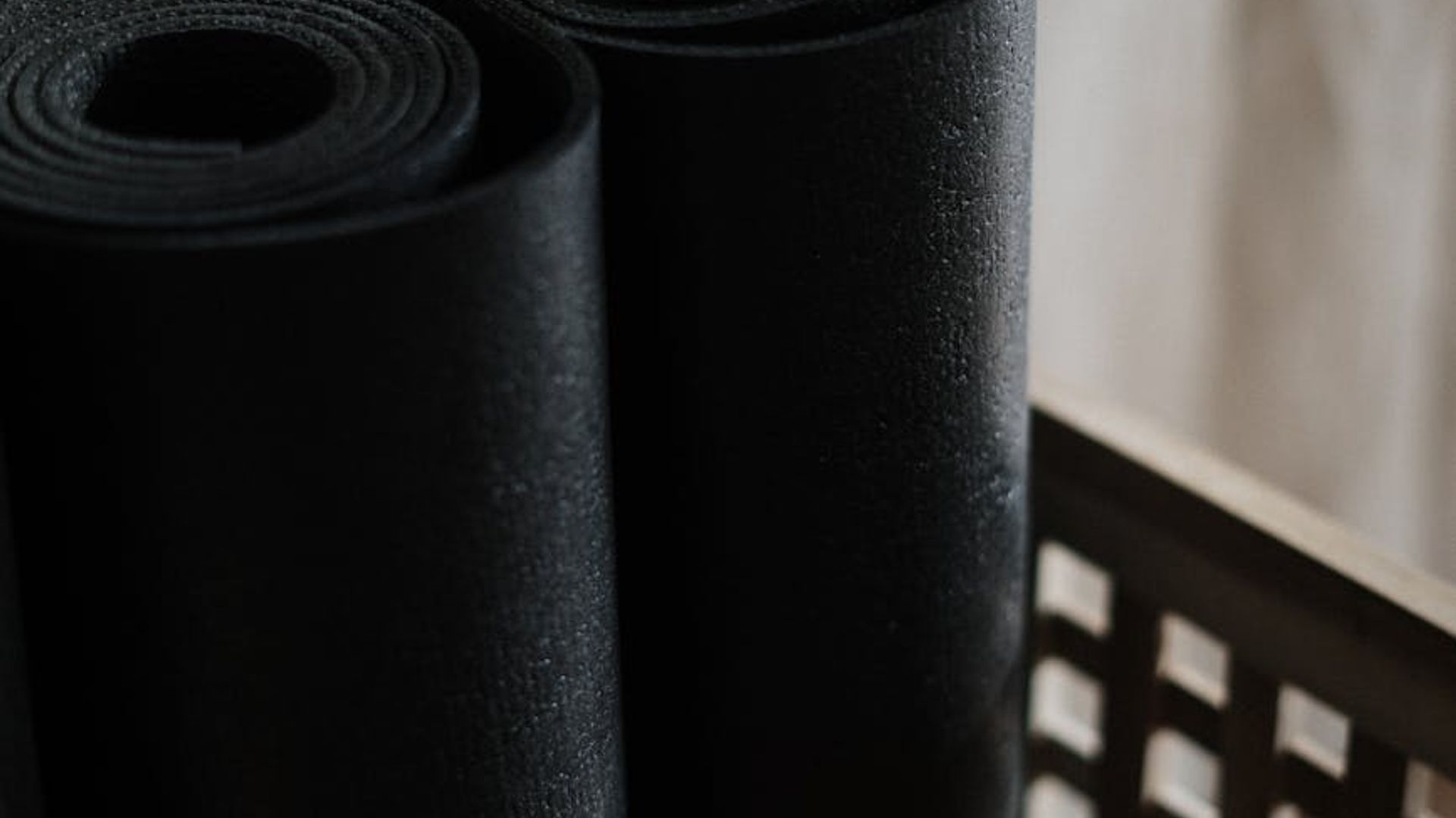 Minimalist dark yoga studio with neon accents and mats.